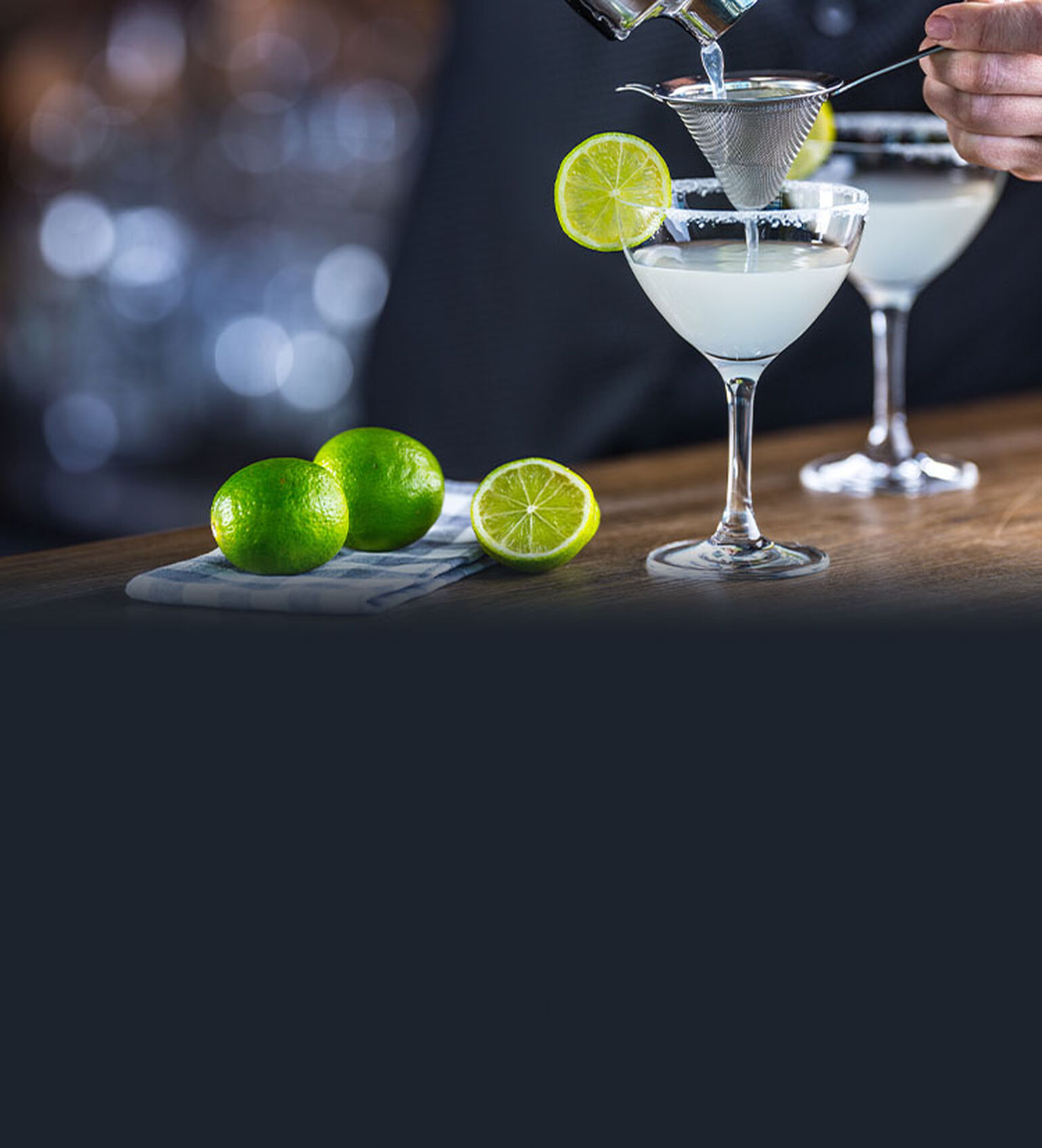 Image of a Daiquiri being prepared on a wood bar top.